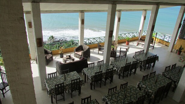 A terrace with tables and chairs, overlooking the ocean. - Pousada Ecobaía (Baia Formosa)