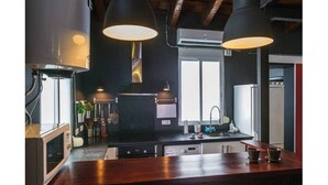 Une cuisine moderne avec un plan de travail en bois, un porte-ustensiles suspendu et des luminaires suspendus.