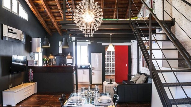 Une cuisine moderne avec un coin repas, un escalier et un espace de vie.