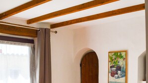Uma área de refeições com uma mesa, cadeiras, uma garrafa e um quadro na parede.