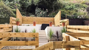 A wooden deck with a central pathway leading to a seating area, surrounded by potted plants. - 2 bedroom accommodation in Burnmouth, near Eyemouth (Burnmouth, near Eyemouth)