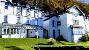 Un grand bâtiment blanc doté de nombreuses fenêtres et d’un patio couvert.