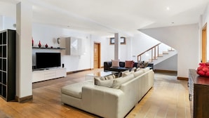 A modern living room with a sofa, TV, and a staircase. - Luxury villas Mamma Mía Villa A Parking & pool private (Playa Blanca)