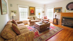 A living room with a sofa, armchairs, a coffee table, and a fireplace.