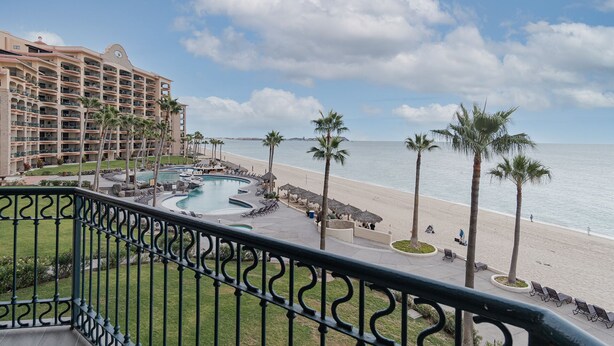 Un resort con piscina, playa y vista al océano.