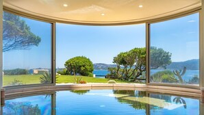 A pool with a clear view of the surrounding landscape, including trees and a body of water. - Holiday House - 5 people, 22 m² living space, 2 bedroom, Internet/WIFI, Internet access (Cannigione di Arzachena)