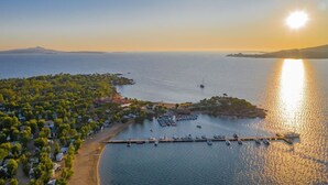 An aerial view of a coastal area with a marina, boats, and a small island with buildings. - Holiday House - 5 people, 22 m² living space, 2 bedroom, Internet/WIFI, Internet access (Cannigione di Arzachena)