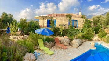 Alberca al aire libre y camastros