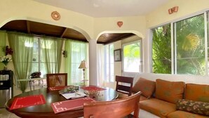 A dining area with a round table, chairs, and a sofa. - Three bedroom apartment with private pool (Sosua)