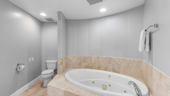 A modern bathroom with a freestanding bathtub, a toilet, and a shower area. - 4th Floor AMAZING Direct Ocean Condo! 2500sqft! (Cocoa Beach)