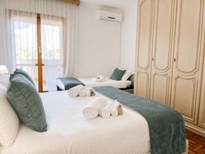 Una habitación de hotel con dos camas, un armario y un equipo de aire acondicionado.
