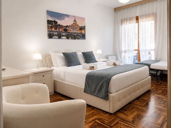 A hotel room with a large bed, bedside tables, a chair, a desk, and a painting of a cityscape.