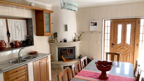 A kitchen with granite countertops, wooden cabinets, a built-in oven, and a dining area with a table and chairs. - Casa da Quinta da Prelada any comfort, Pool, Terrace, Big spaces, Fafe (Rego)