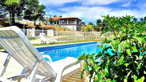 A swimming pool with white lounge chairs, a fenced area, and a house in the background. - Casa da Quinta da Prelada any comfort, Pool, Terrace, Big spaces, Fafe (Rego)