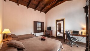 Una camera da letto con due letti, una scrivania con un computer e una sedia.