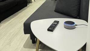 Un salon moderne avec une table blanche, un canapé noir et un divan gris.