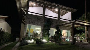 A modern two-story house with a glass facade, outdoor seating area, and a well-maintained lawn. - House in the Mountains - Exclusive view! (Gravatá)