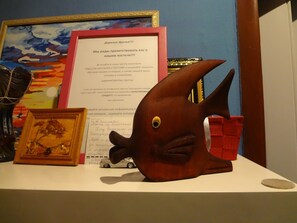 Awards and artwork adorn the wall, complemented by a unique wooden sculpture.