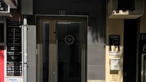 A building entrance with a glass door, a fire hydrant in front, and a sign for 'Tyco Interactive Security'. - Francisco Cano bowling (Fuengirola)