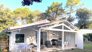 Une maison dotée d’un patio couvert, d’un coin repas et d’une cuisine.