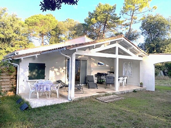A house with a covered patio, a dining area, and a kitchen.
