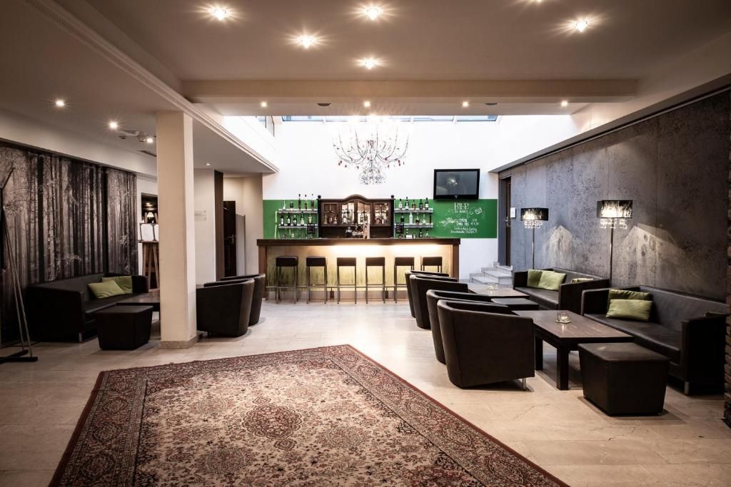 A spacious lobby with a bar area, seating arrangements, and a chandelier.