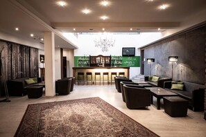 A spacious lobby with a bar area, seating arrangements, and a chandelier. - Faulenzerhotel (Zwettl)