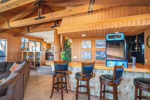 A wooden interior with a bar area, cushioned bar stools, and a large map on the wall.