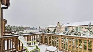 Eine Holzterrasse mit schneebedeckten Stühlen und einem Geländer.