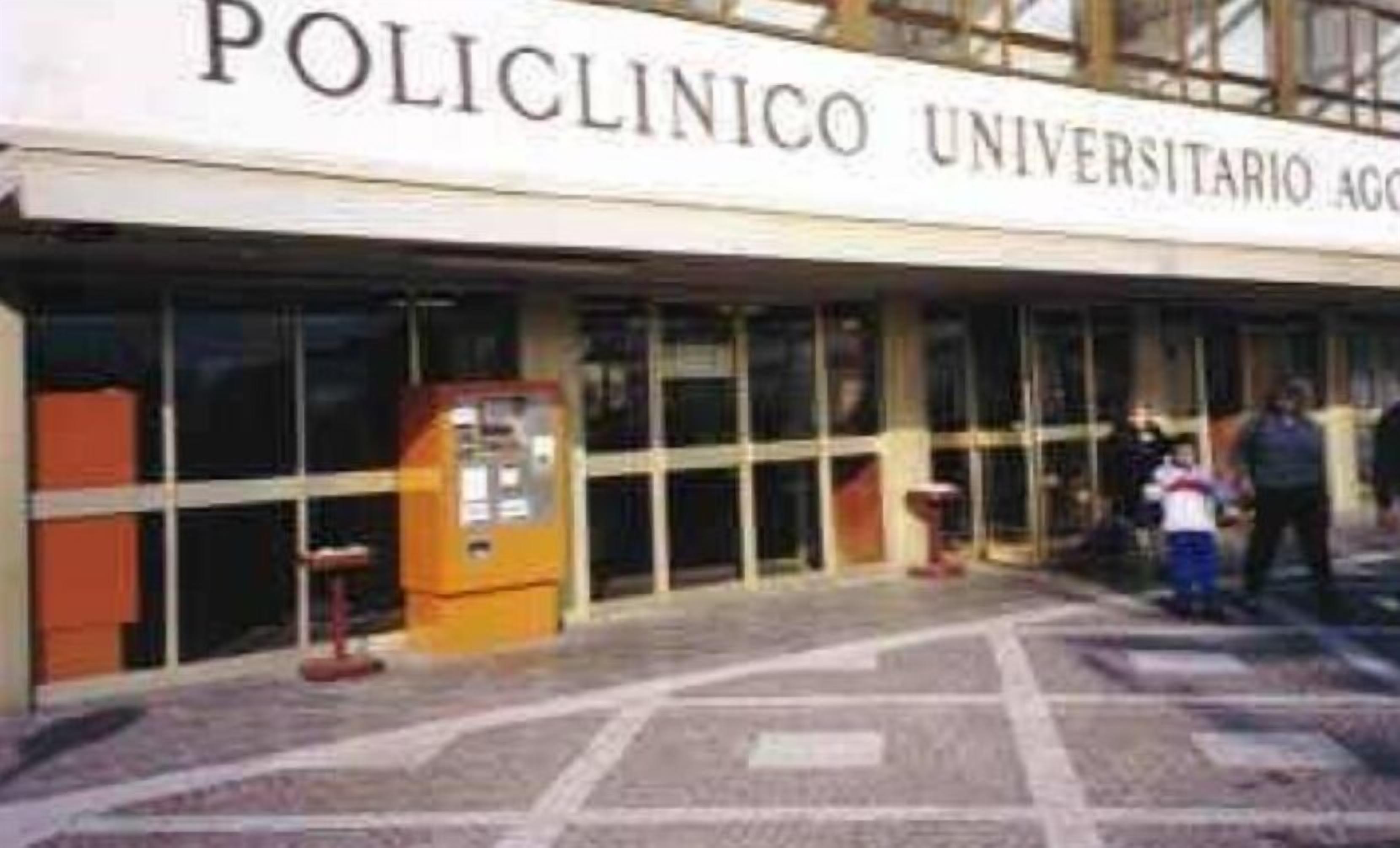 Das Gebäude von außen mit einem Schild, auf dem 'POLICLINICO UNIVERSITARIO' steht.