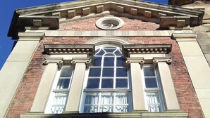 A building with a classical architectural style, featuring a prominent pediment, columns, and a large arched window with decorative elements. - 1 bedroom accommodation in Wirksworth, near Matlock (Wirksworth, near Matlock)