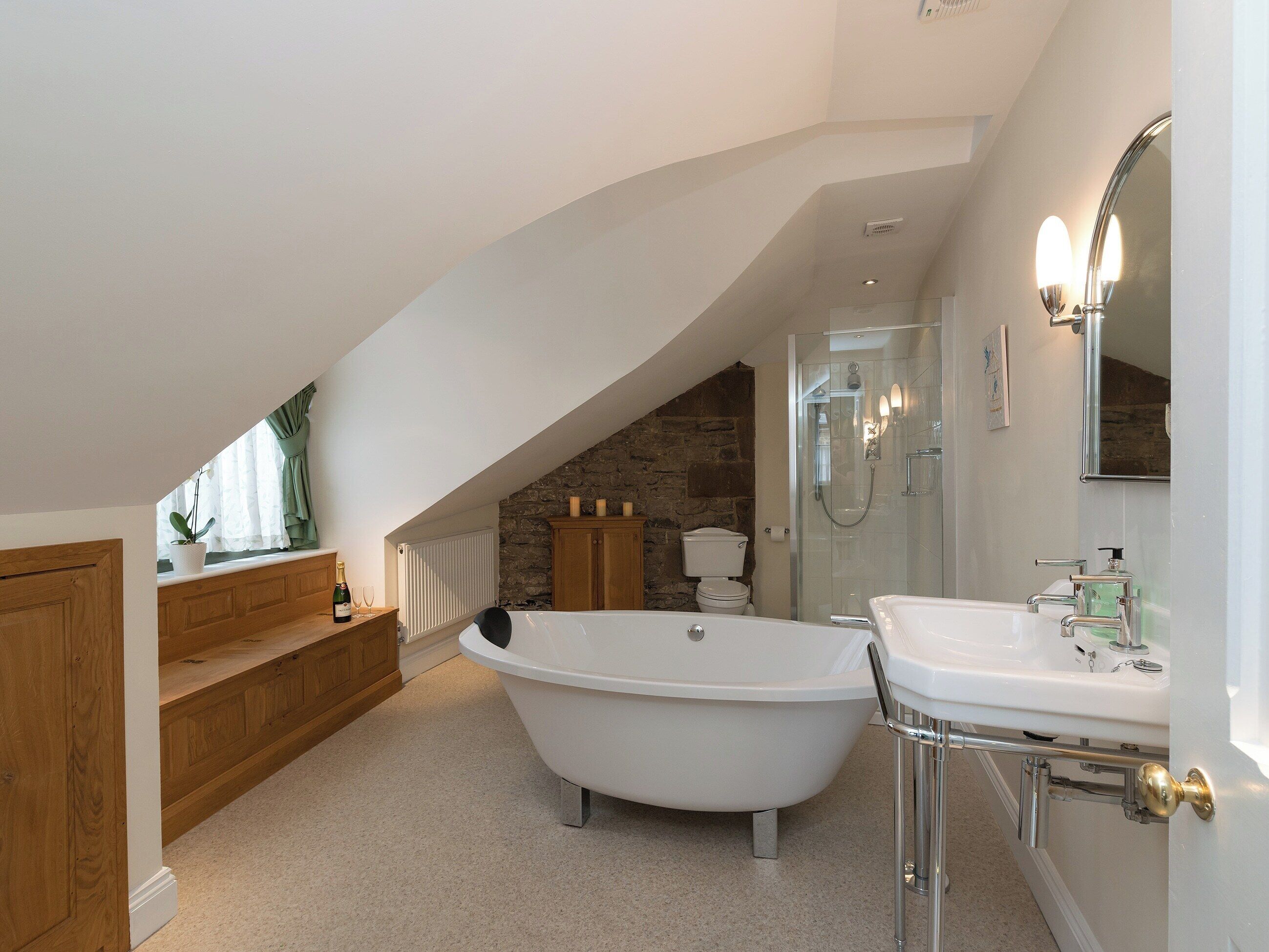 A modern bathroom with a freestanding bathtub, a glass-enclosed shower, and a vanity with a mirror.