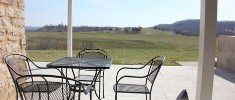 Eine Terrasse mit einer Steinmauer, Metallstühlen und einem Tisch.