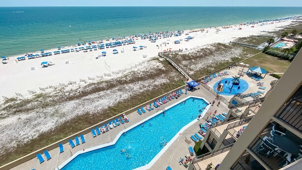 Ein Resort mit großem Schwimmbad, Strandbereich und Blick auf den Ozean.