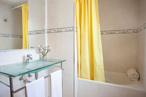 A bathroom with a glass sink, a mirror, a yellow shower curtain, and a white towel on the floor. - Marina dór IV, house 5, wifi 5 bedrooms, community pool, beach 300m away (Santanyí)