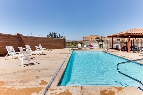 Relax by the pool surrounded by lounge chairs and a shaded pavilion.