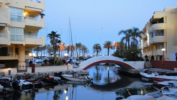 A marina with boats docked, a bridge, and palm trees. - BEAUTIFUL APARTMENT NEAR THE BEACH AND THE MOUNTAIN (Benalmádena)