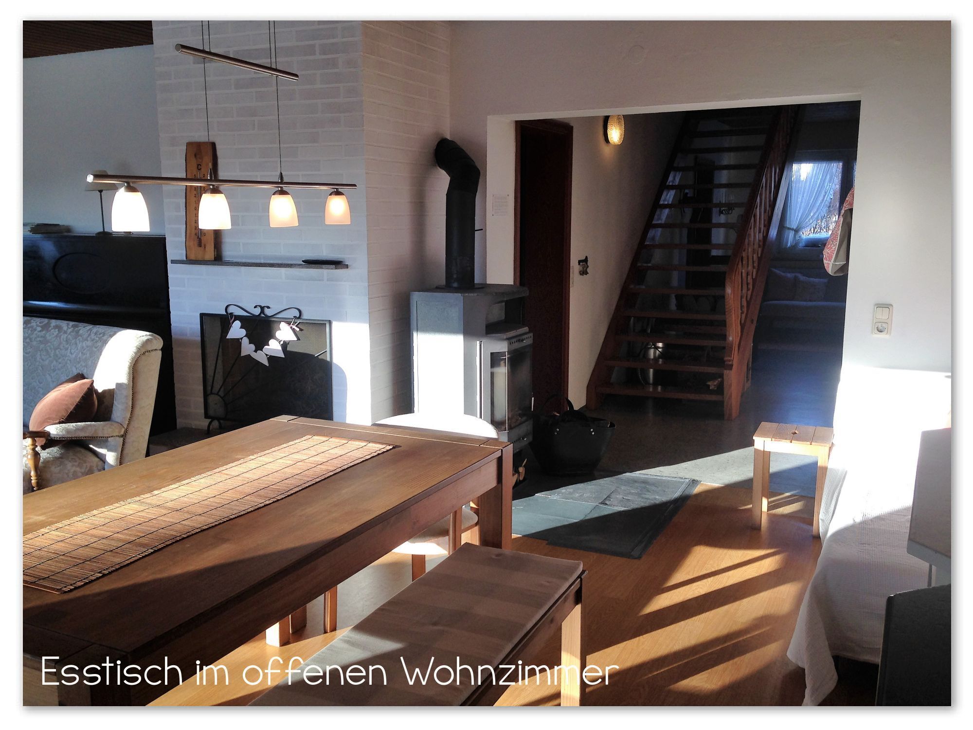 Offenes Erdgeschoss mit Flur, Esstisch und Wohnzimmer mit Sofas und Gartenzugang