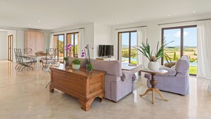 Un salon spacieux avec un grand canapé, un meuble en bois et un téléviseur.