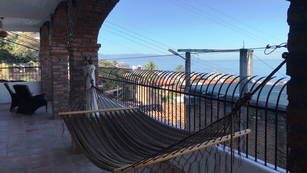A balcony with a hammock, brick walls, and a view of the sea. - Spacious bright tiled 2 bedroom with Ocean View (Cerro)