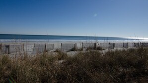 A beach with a wooden fence and tall grasses in the foreground. - Great Room w/ Ocean View at Resort + Official On-Site Rental Privileges (Myrtle Beach)