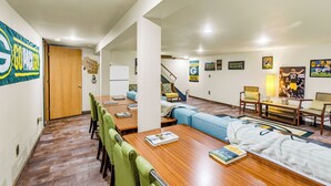 A hotel room with a dining area, a sofa, a bed, and a staircase.
