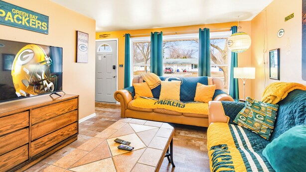 A living room with a couch, a television, and a wooden dresser.
