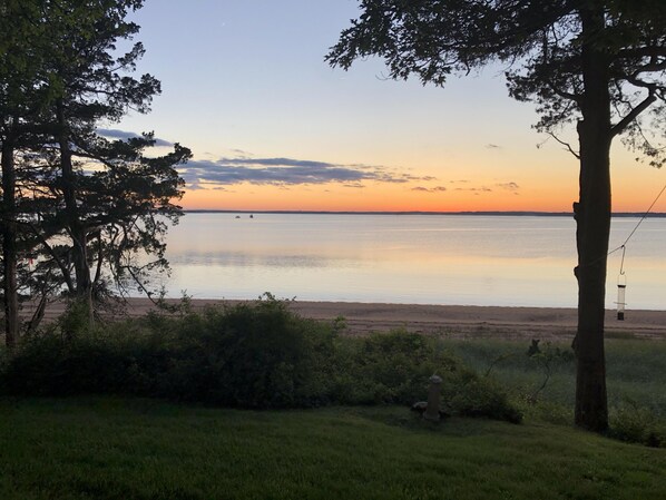 A serene lakeside view with trees and a clear sky.