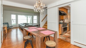 A spacious kitchen with wooden cabinets, a large island, and a chandelier. - Stunning Bayfront Views (Hampton Bays)