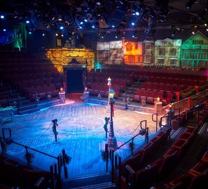 A theater with a stage, rows of red seats, and a wooden floor. - All the comforts of home in the Arizona sun! (Gilbert)