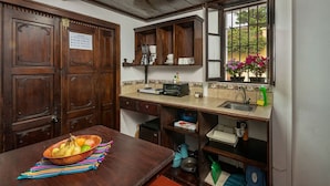 A kitchen with wooden cabinets, a countertop with appliances, and a window with a view of flowers.