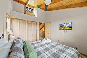 A bedroom with a bed, a nightstand, a lamp, and a painting on the wall. - Mountain Cottage near Outdoor Activities (Sugar Mountain)
