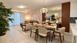Un espace repas moderne avec une table et des chaises en bois, un canapé et un grand miroir.