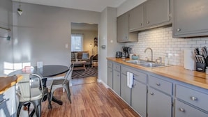 Una cocina moderna con armarios grises, encimera de madera y un lavabo.